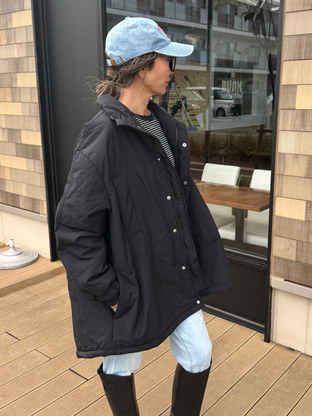 ブラック系のTシャツ/カットソー、ブルー系のデニムパンツ、ブラック系のジャケット/アウターを着用したレディースの秋コーディネートの5枚目の写真