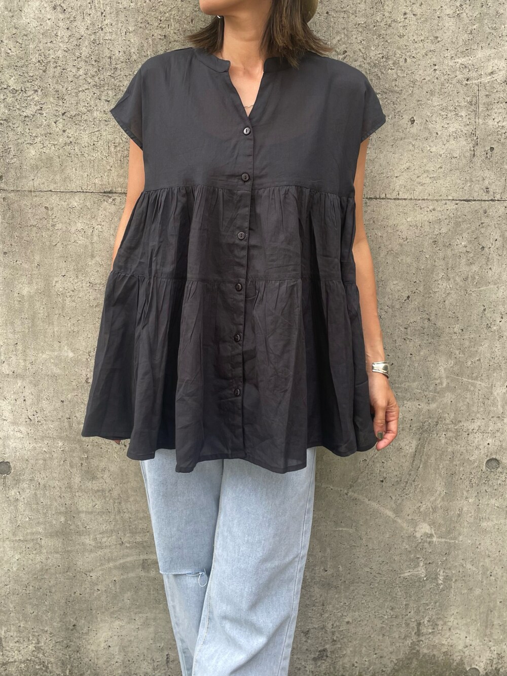 ブラック系のシャツ/ブラウス、ブルー系のデニムパンツ、ブラック系のサンダルを着用したレディースの夏コーディネートの5枚目の写真