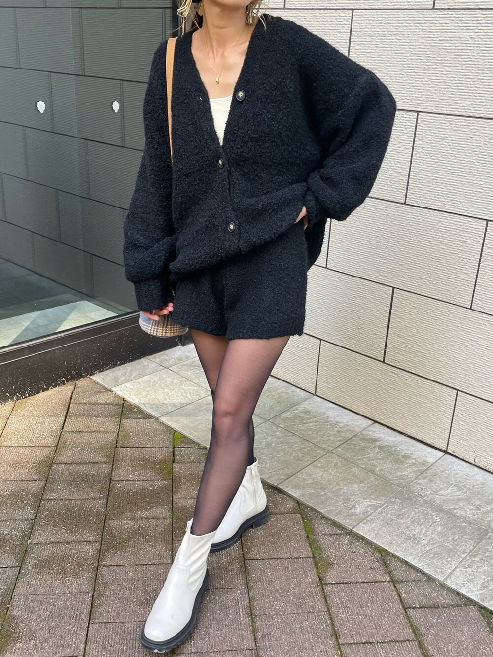 ホワイト系のブーツ、その他のショルダーバッグ、ゴールド系のネックレスを着用したレディースの秋コーディネートの2枚目の写真