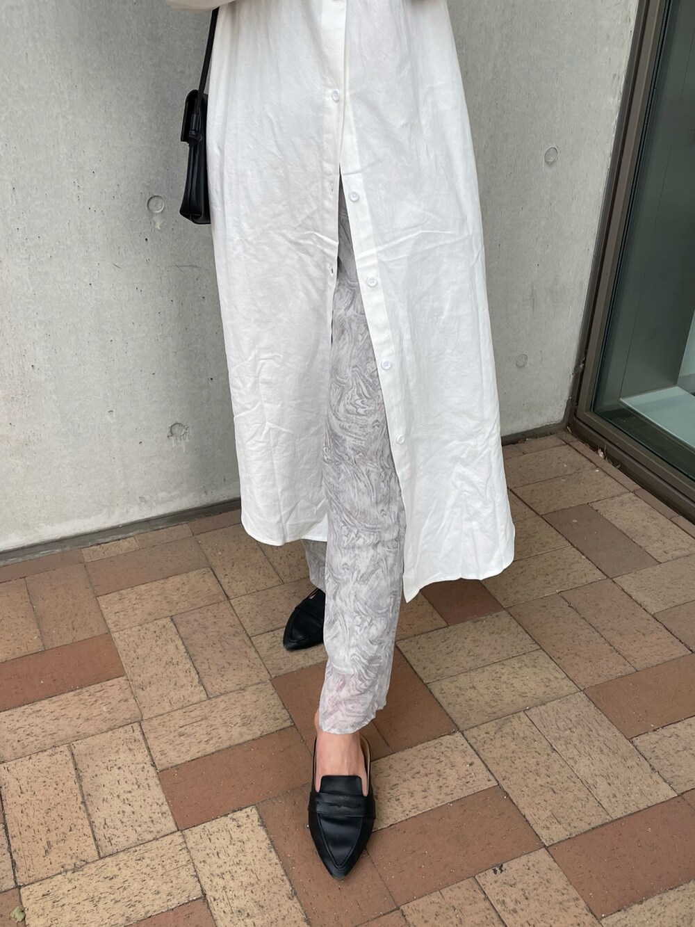 ホワイト系のシャツワンピース、グレー系のその他パンツ、ベージュ系のショルダーバッグを着用したレディースの春コーディネートの5枚目の写真