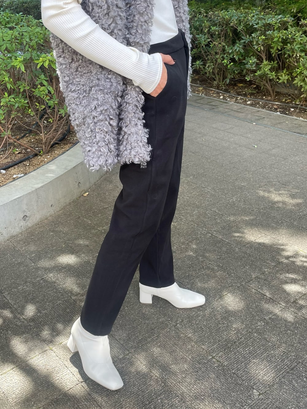グレー系のベスト、ホワイト系のTシャツ/カットソー、ブラック系のその他パンツを着用したレディースの秋コーディネートの5枚目の写真