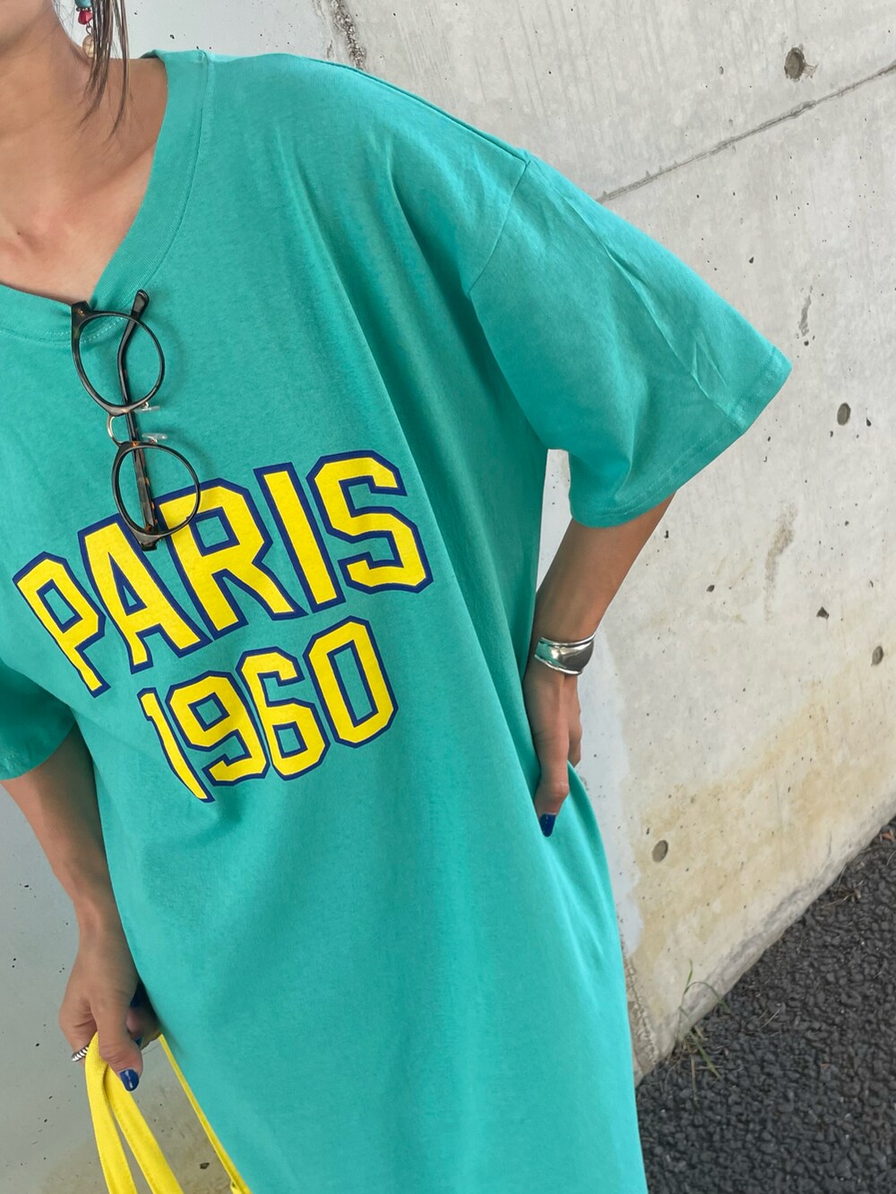 ブルー系のワンピース、イエロー系のトートバッグ、ホワイト系のスニーカーを着用したレディースの春コーディネートの5枚目の写真