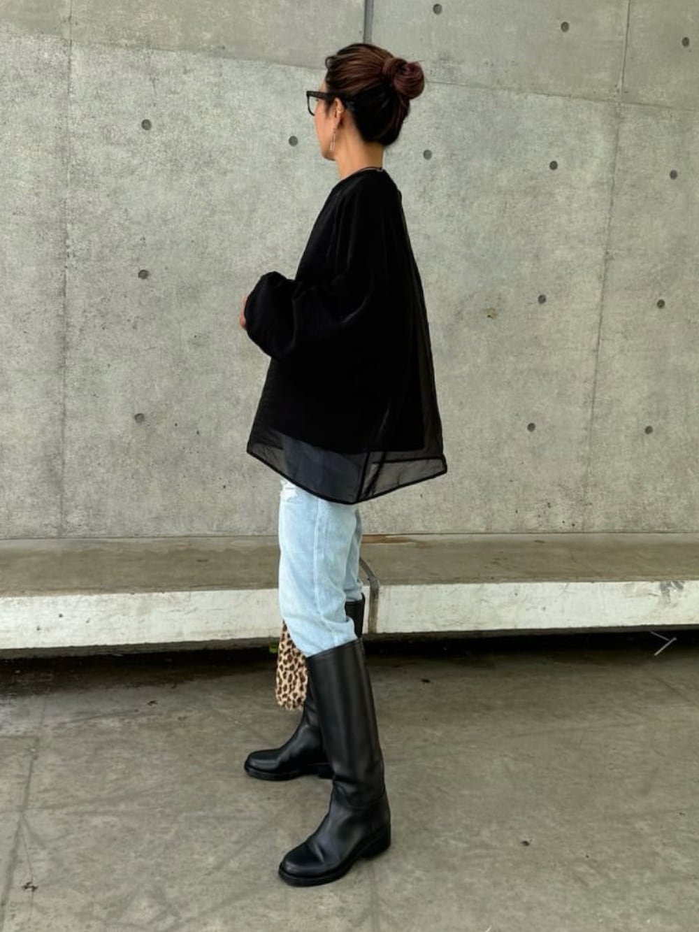 ブラック系のスウェット、ブルー系のデニムパンツ、その他のショルダーバッグを着用したレディースの秋コーディネートの2枚目の写真