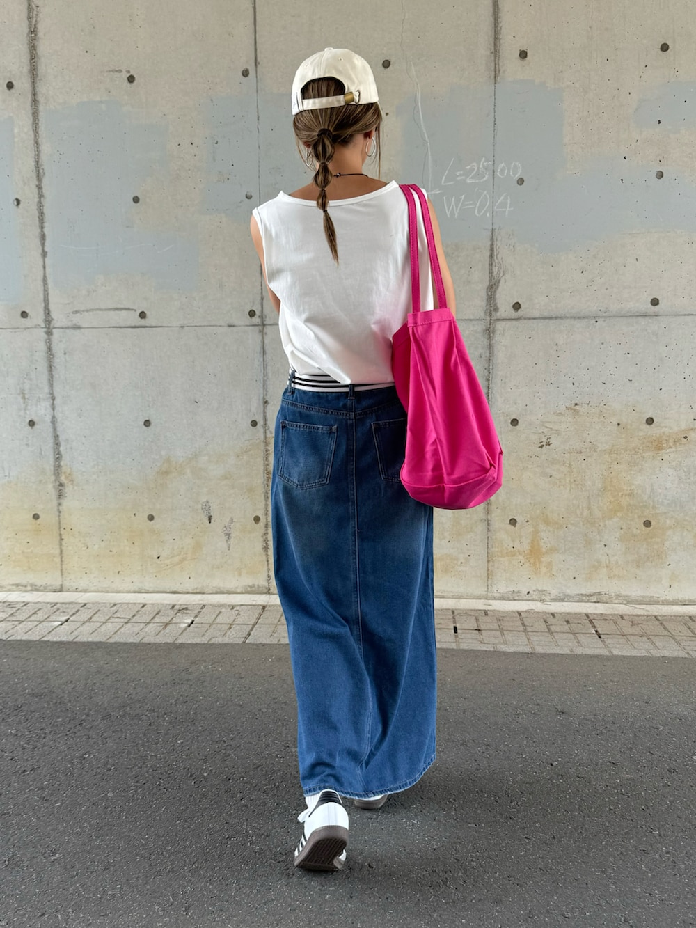 ブルー系のデニムスカート、ピンク系のトートバッグ、ホワイト系のスニーカーを着用したレディースの夏コーディネートの4枚目の写真