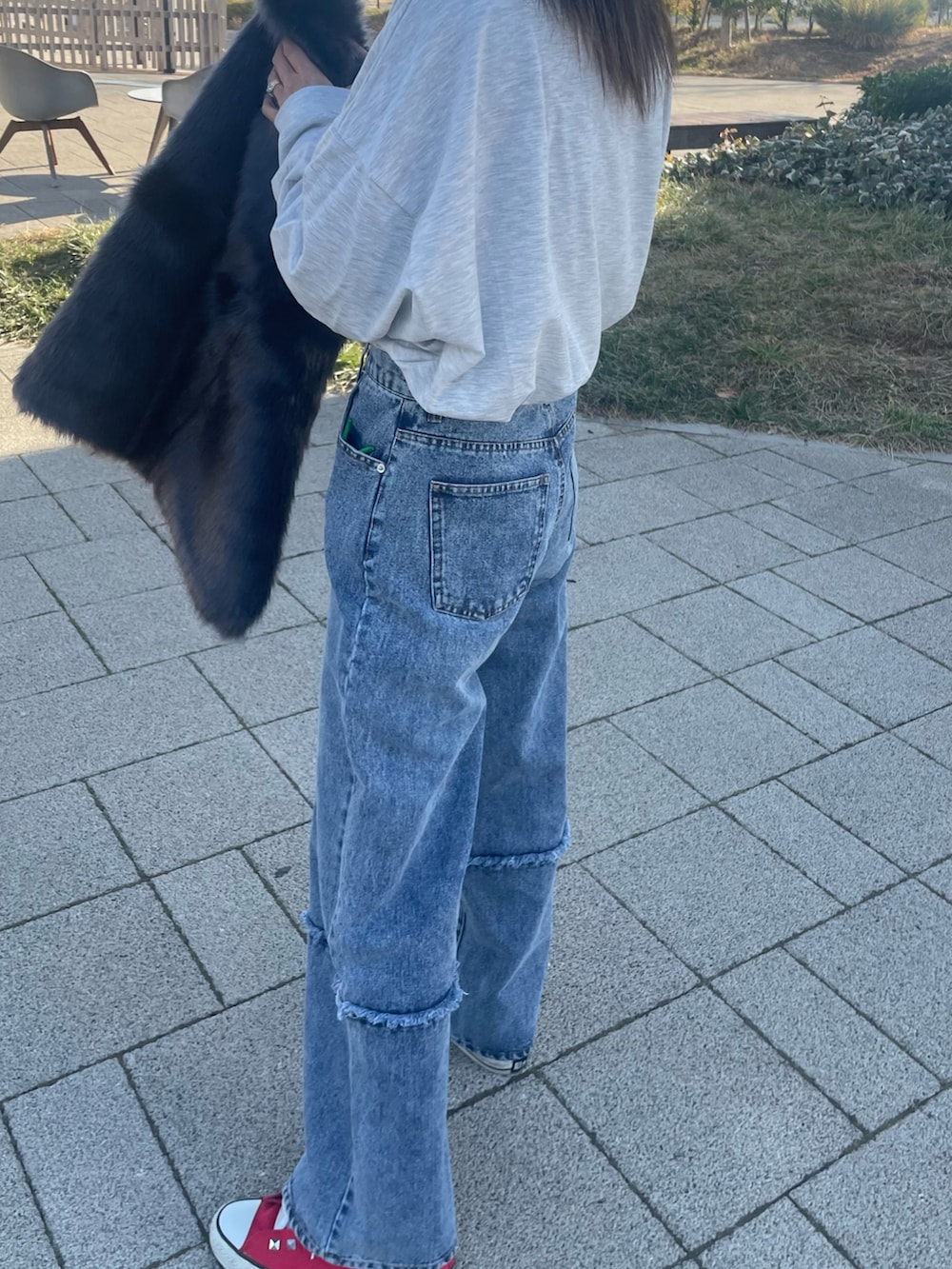 ホワイト系のTシャツ/カットソー、グレー系のベスト、ブルー系のデニムパンツを着用したレディースの冬コーディネートの3枚目の写真