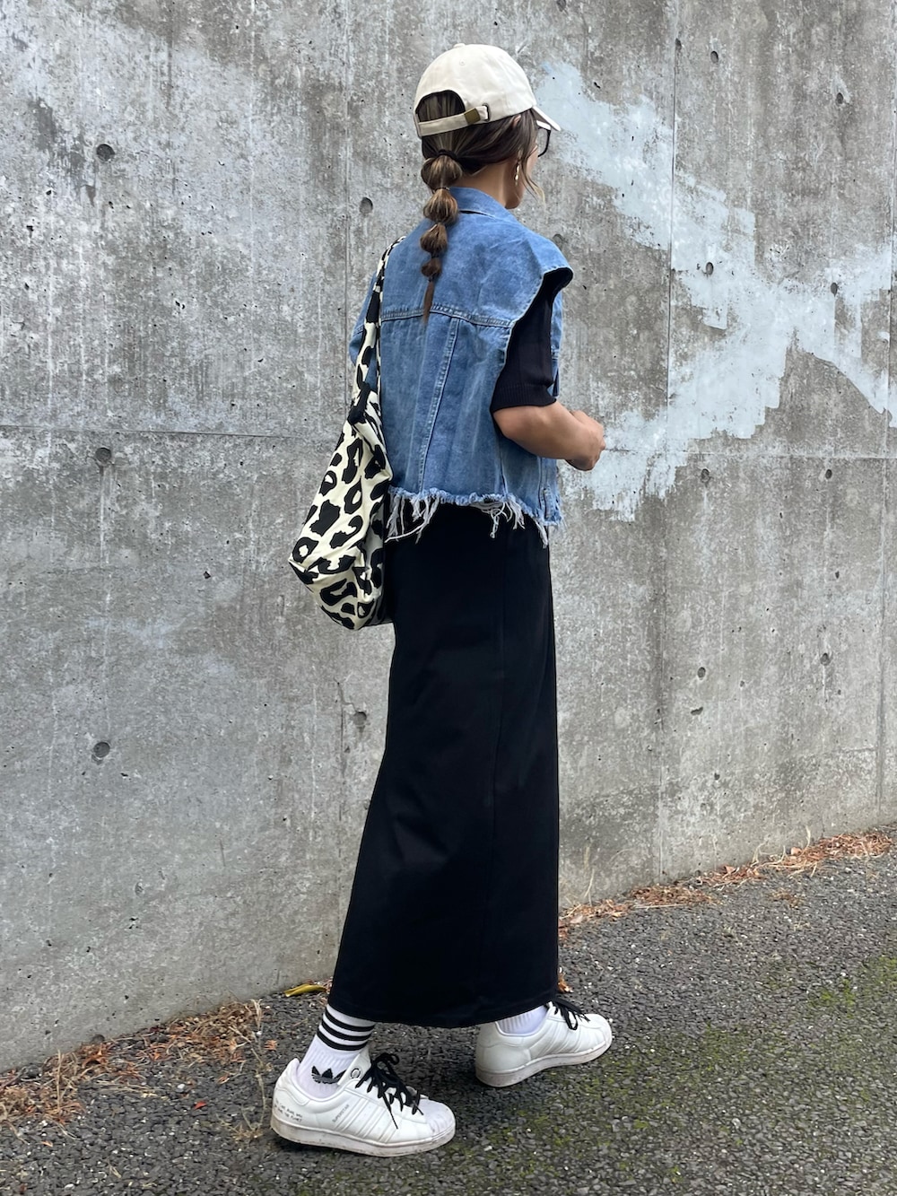 ブラック系のTシャツ/カットソー、ブルー系のベスト、ブラック系のスカートを着用したレディースの春コーディネートの4枚目の写真