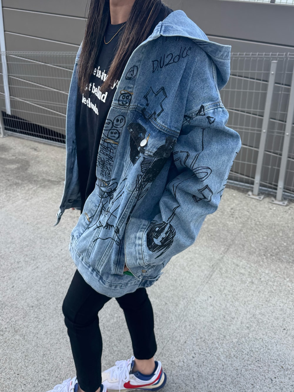 ブラック系のTシャツ/カットソー、ブルー系のデニムジャケット、ブラック系のデニムパンツを着用したレディースの春コーディネートの4枚目の写真