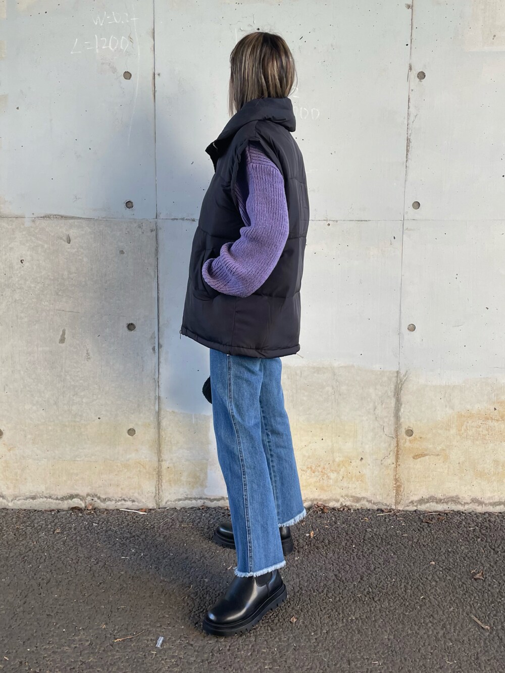 ブルー系のニット/セーター、ブラック系のダウンベスト、ブルー系のデニムパンツを着用したレディースの冬コーディネートの2枚目の写真