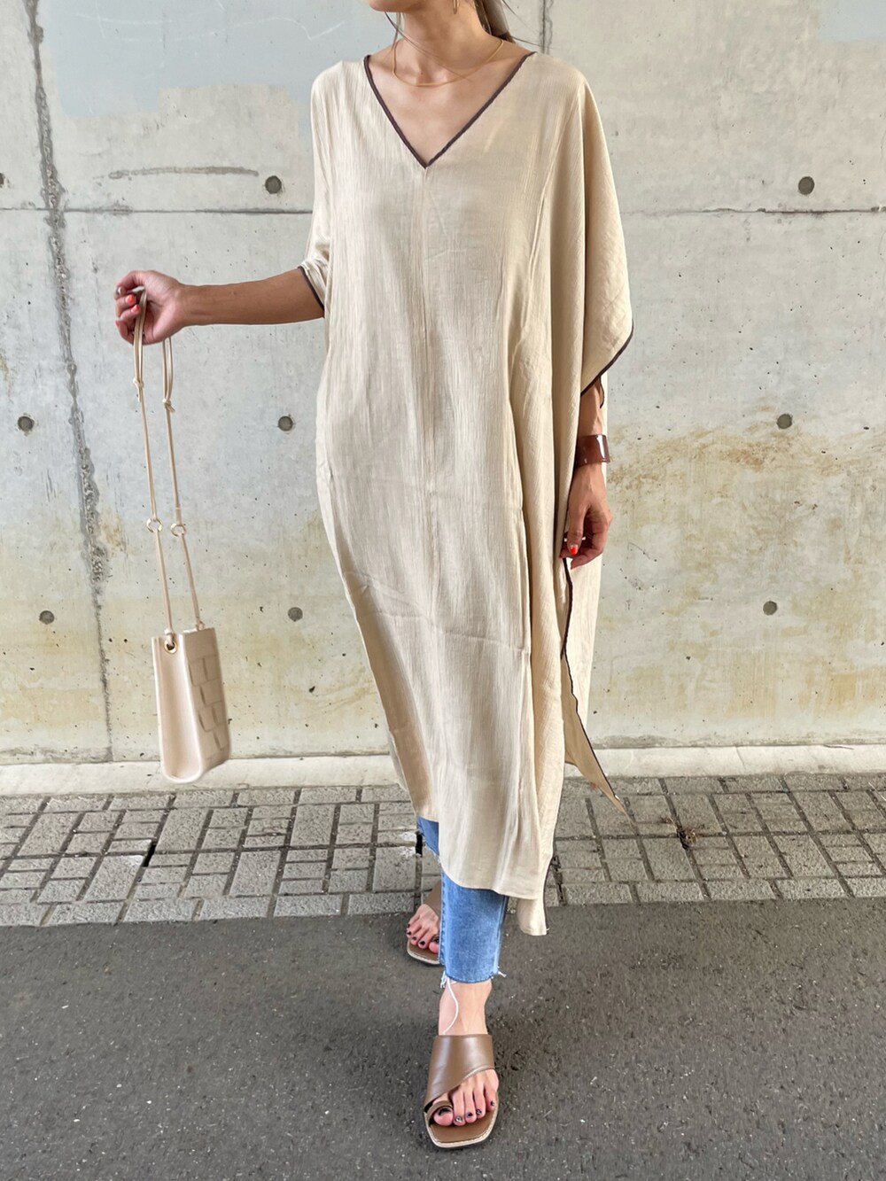 ベージュ系のワンピース、ブルー系のデニムパンツ、ブラウン系のサンダルを着用したレディースの夏コーディネートの5枚目の写真