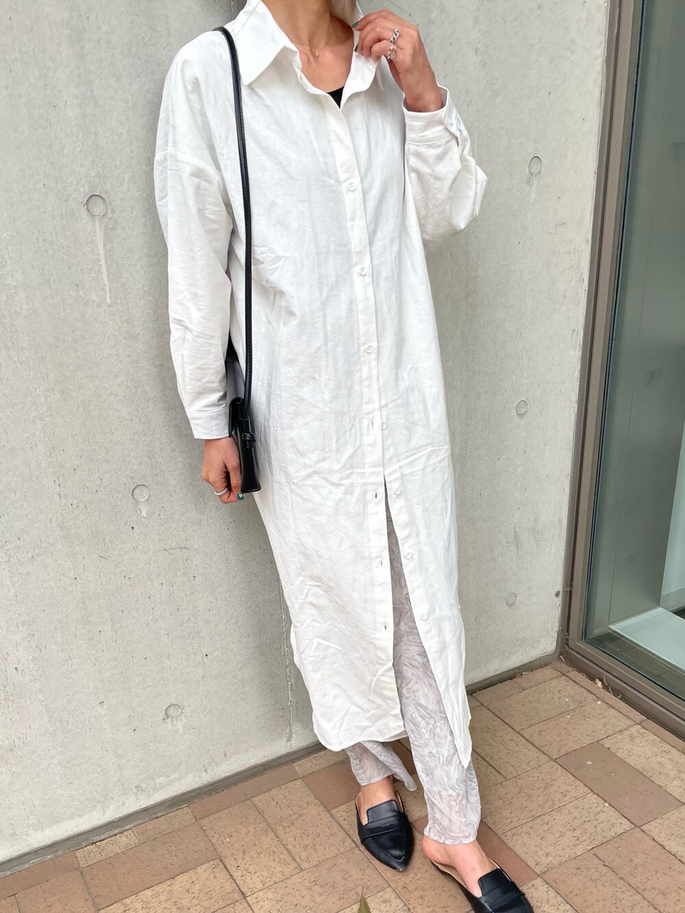 ホワイト系のシャツワンピース、グレー系のその他パンツ、ベージュ系のショルダーバッグを着用したレディースの春コーディネートの2枚目の写真