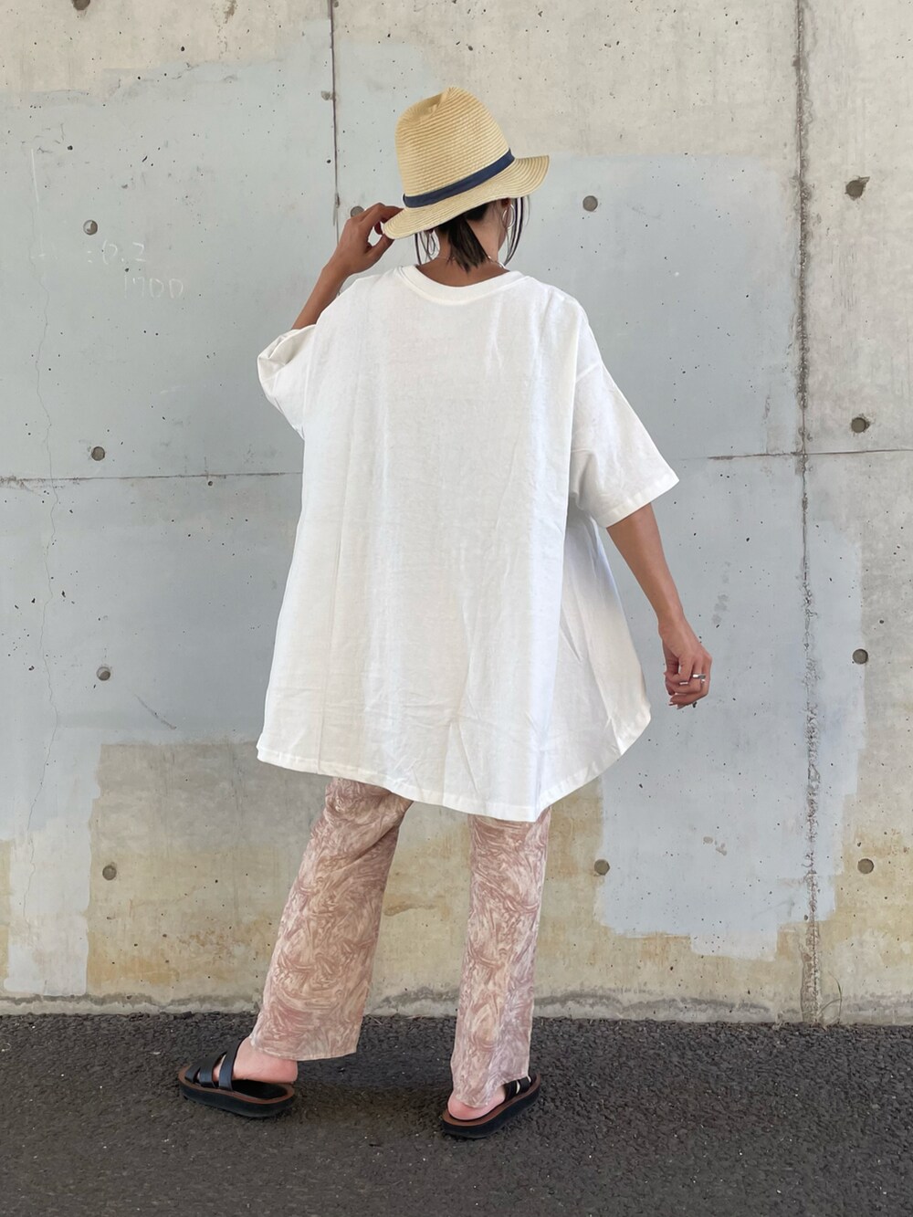 ホワイト系のTシャツ/カットソー、オレンジ系のその他パンツ、ブラック系のサンダルを着用したレディースの春コーディネートの3枚目の写真