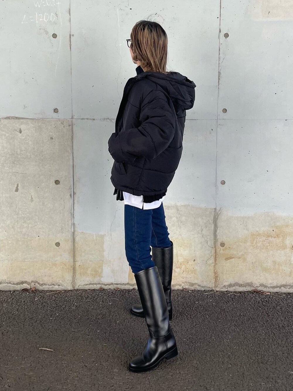 ブラック系のニット/セーター、ブルー系のデニムパンツ、ブラック系のダウンジャケット/コートを着用したレディースの秋コーディネートの2枚目の写真