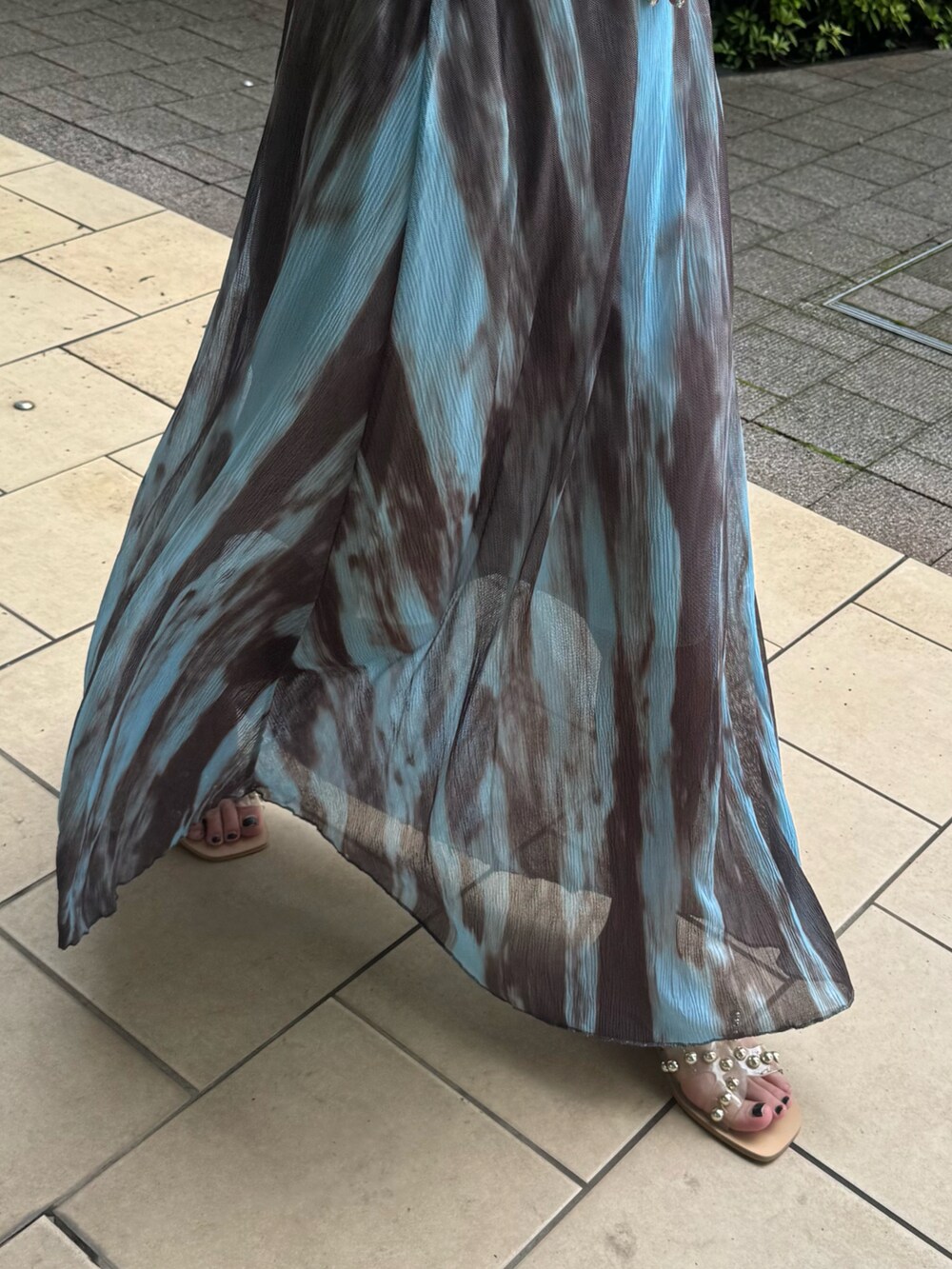 ブラック系のタンクトップ、ブルー系のスカート、ベージュ系のサンダルを着用したレディースの夏コーディネートの4枚目の写真