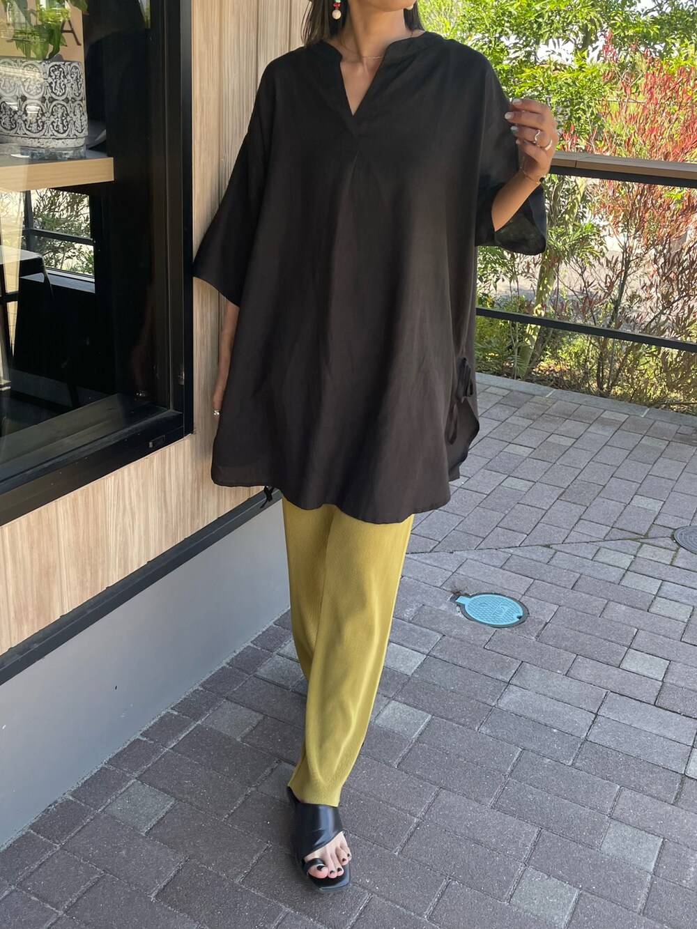 ブラック系のシャツ/ブラウス、ブラウン系のサンダル、ベージュ系のハットを着用したレディースの春コーディネートの3枚目の写真