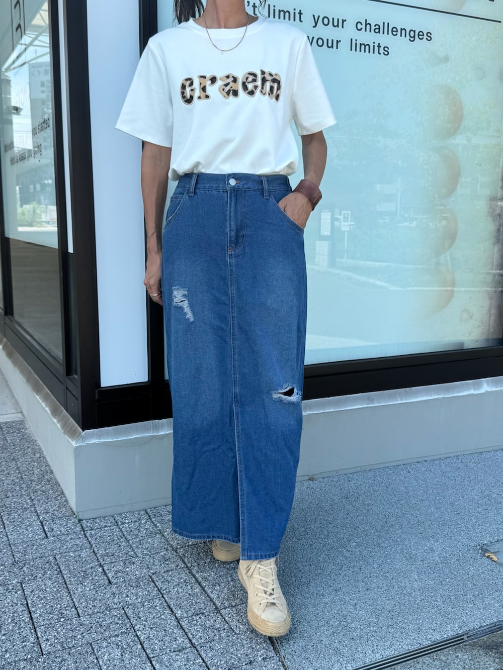 ホワイト系のTシャツ/カットソー、ブルー系のデニムスカート、ベージュ系のスニーカーを着用したレディースの秋コーディネートの3枚目の写真