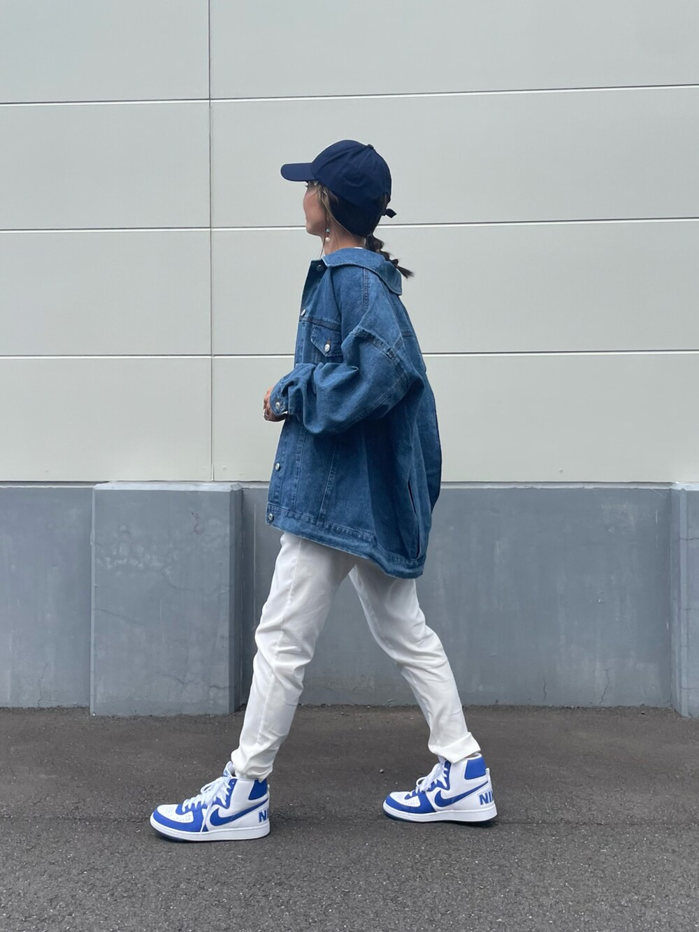 ブルー系のデニムジャケット、ホワイト系のその他パンツ、ブルー系のスニーカーを着用したレディースの秋コーディネートの2枚目の写真