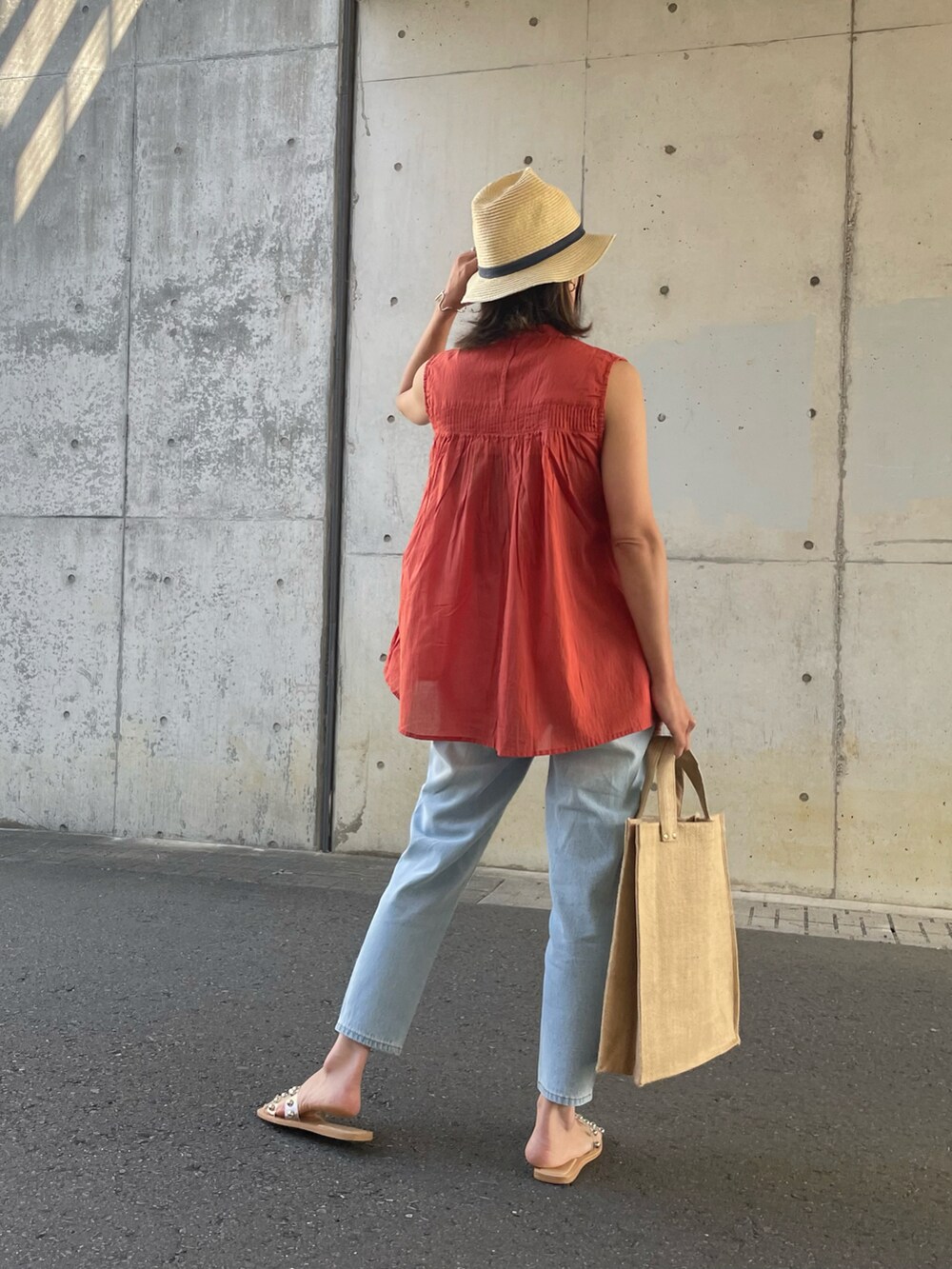 レッド系のシャツ/ブラウス、ブルー系のデニムパンツ、ブルー系のトートバッグを着用したレディースの夏コーディネートの3枚目の写真