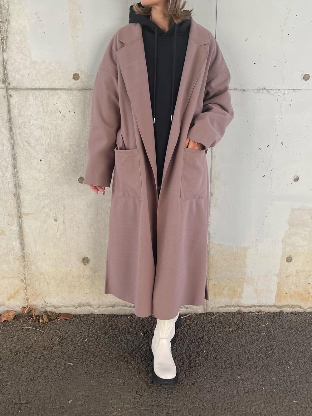 ブラウン系のチェスターコート、ブラック系のパーカー、ブラック系のその他パンツを着用したレディースの秋コーディネートの3枚目の写真