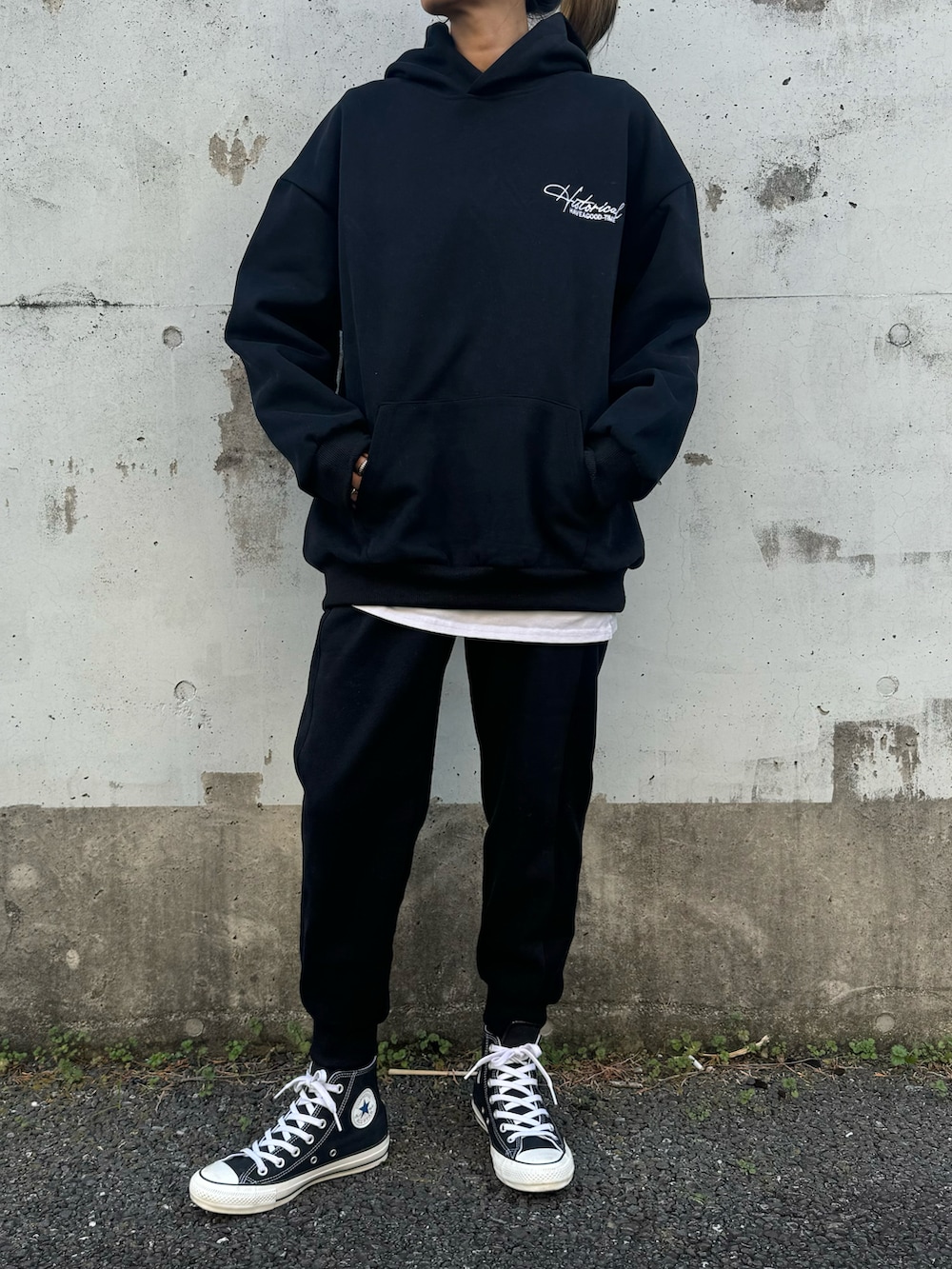 ブラック系のパーカー、ブラック系のスウェットパンツ、ブラック系のスニーカーを着用したレディースの冬コーディネートの3枚目の写真