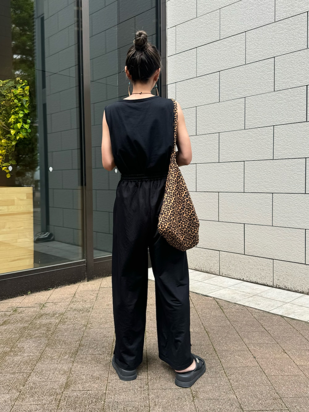 ブラック系のタンクトップ、ブラック系のその他パンツ、ブラウン系のショルダーバッグを着用したレディースの夏コーディネートの3枚目の写真