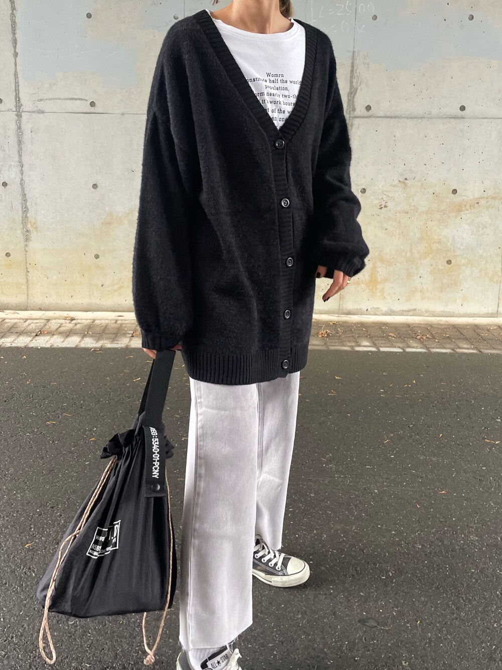 ブラック系のカーディガン/ボレロ、パープル系のデニムパンツ、ブラック系のスニーカーを着用したレディースの冬コーディネートの4枚目の写真