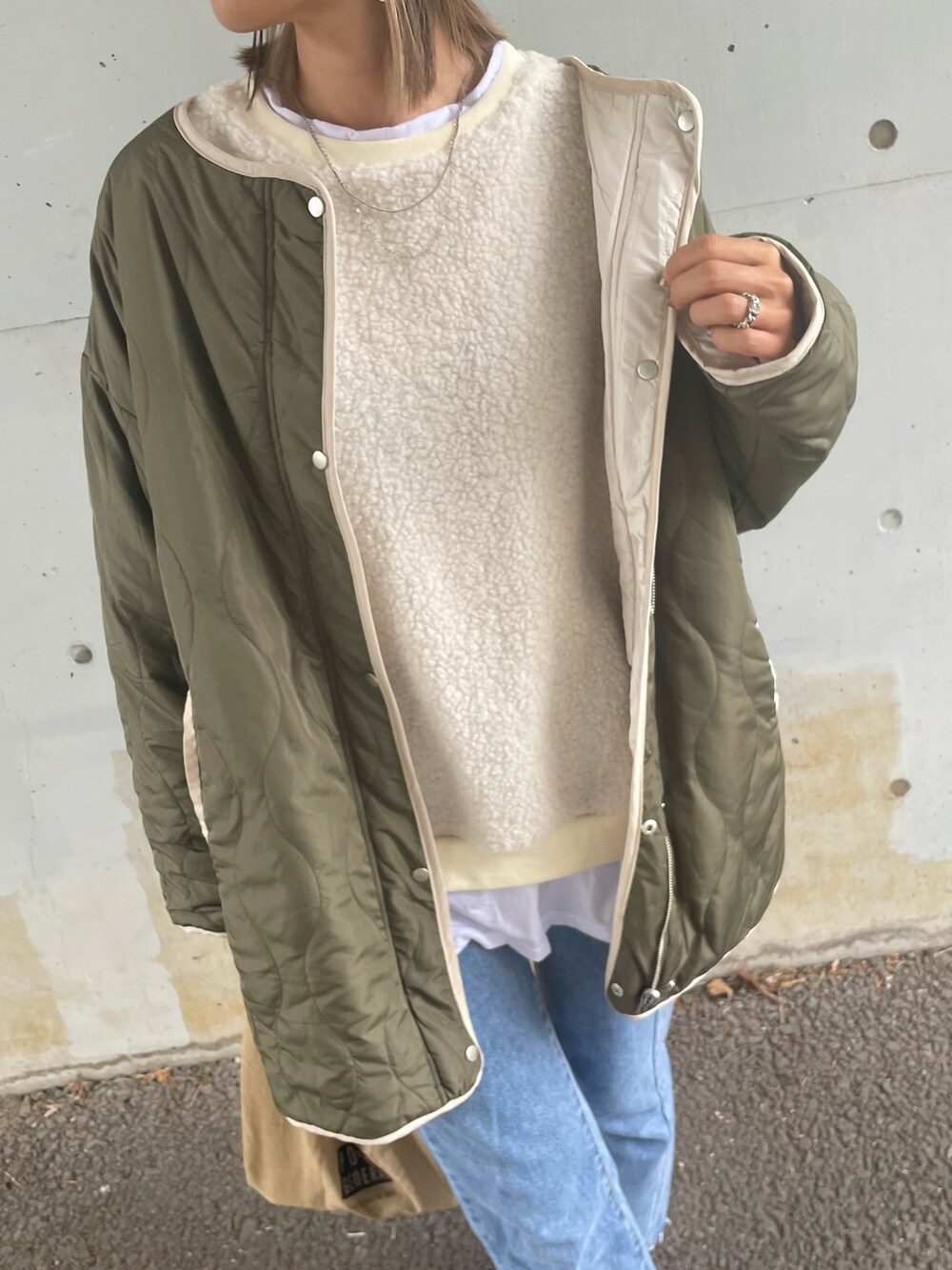 グリーン系のその他アウター、ホワイト系のスウェット、ブルー系のデニムパンツを着用したレディースの秋コーディネートの5枚目の写真