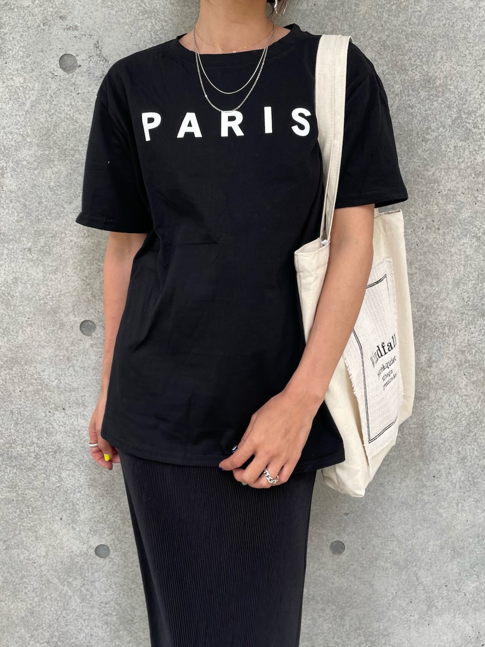 ブラック系のTシャツ/カットソー、ブラック系のスカート、ホワイト系のトートバッグを着用したレディースの夏コーディネートの3枚目の写真