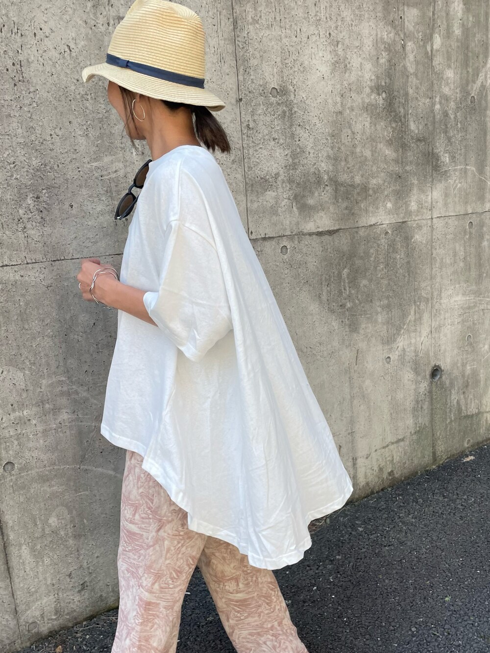 ホワイト系のTシャツ/カットソー、オレンジ系のその他パンツ、ブラック系のサンダルを着用したレディースの春コーディネートの4枚目の写真