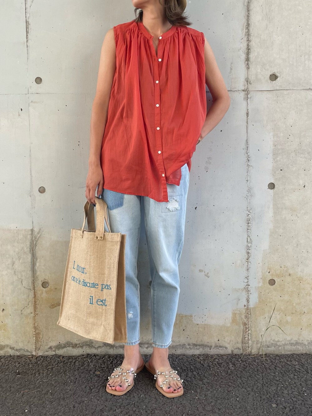 レッド系のシャツ/ブラウス、ブルー系のデニムパンツ、ブルー系のトートバッグを着用したレディースの夏コーディネートの2枚目の写真