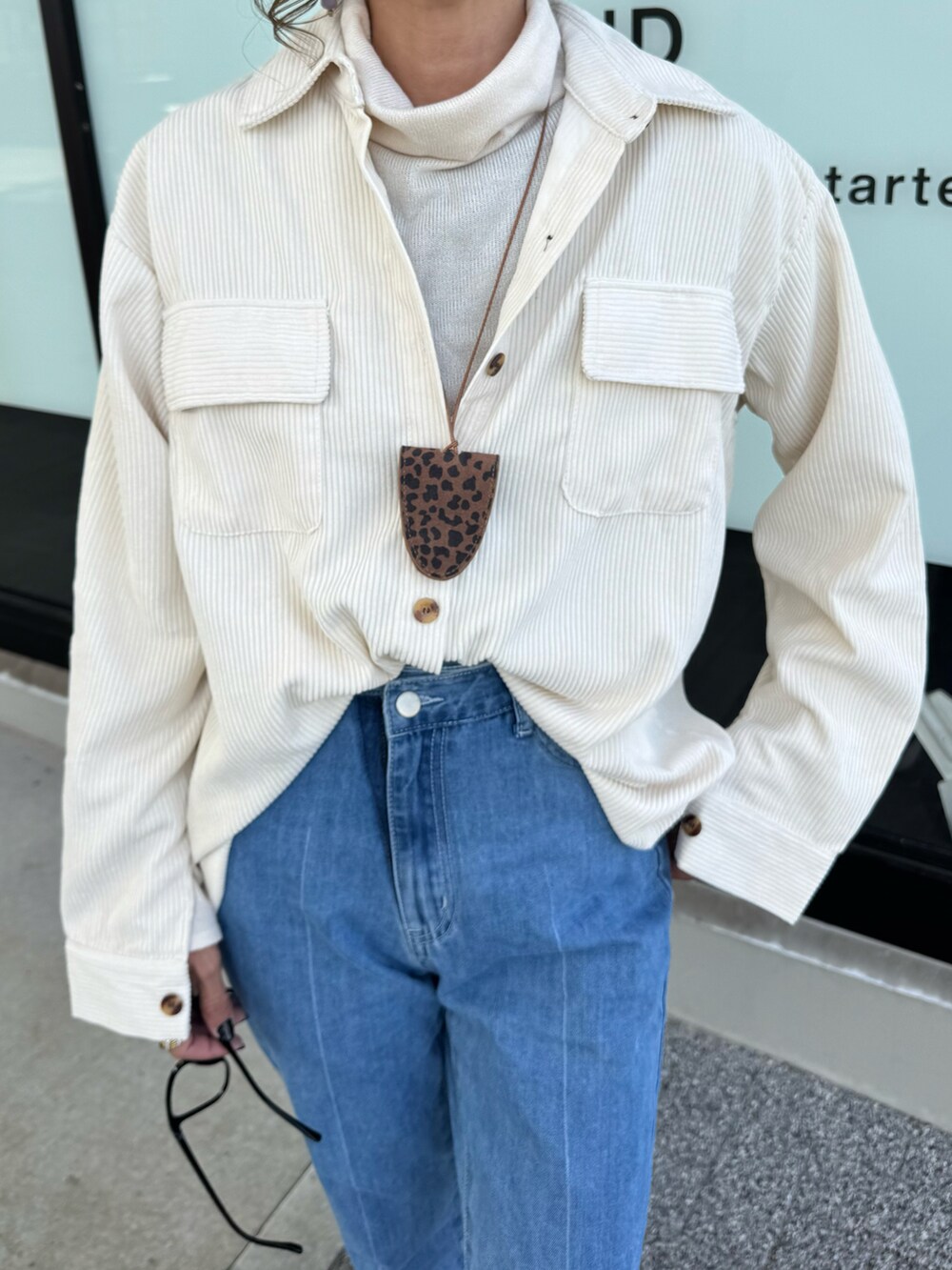 ホワイト系のニット/セーター、ブルー系のデニムパンツ、レッド系のショルダーバッグを着用したレディースの秋コーディネートの5枚目の写真