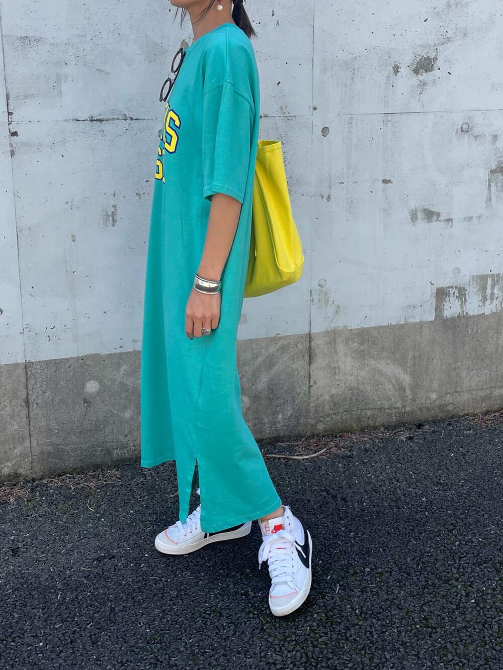 ブルー系のワンピース、イエロー系のトートバッグ、ホワイト系のスニーカーを着用したレディースの春コーディネートの4枚目の写真