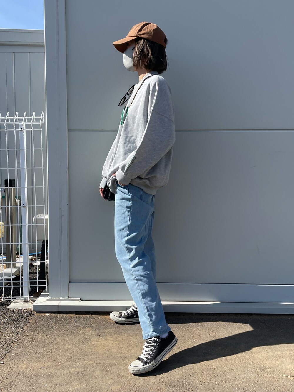 ブルー系のデニムパンツ、ブラック系のスニーカー、ブラウン系のキャップを着用したレディースの冬コーディネートの3枚目の写真