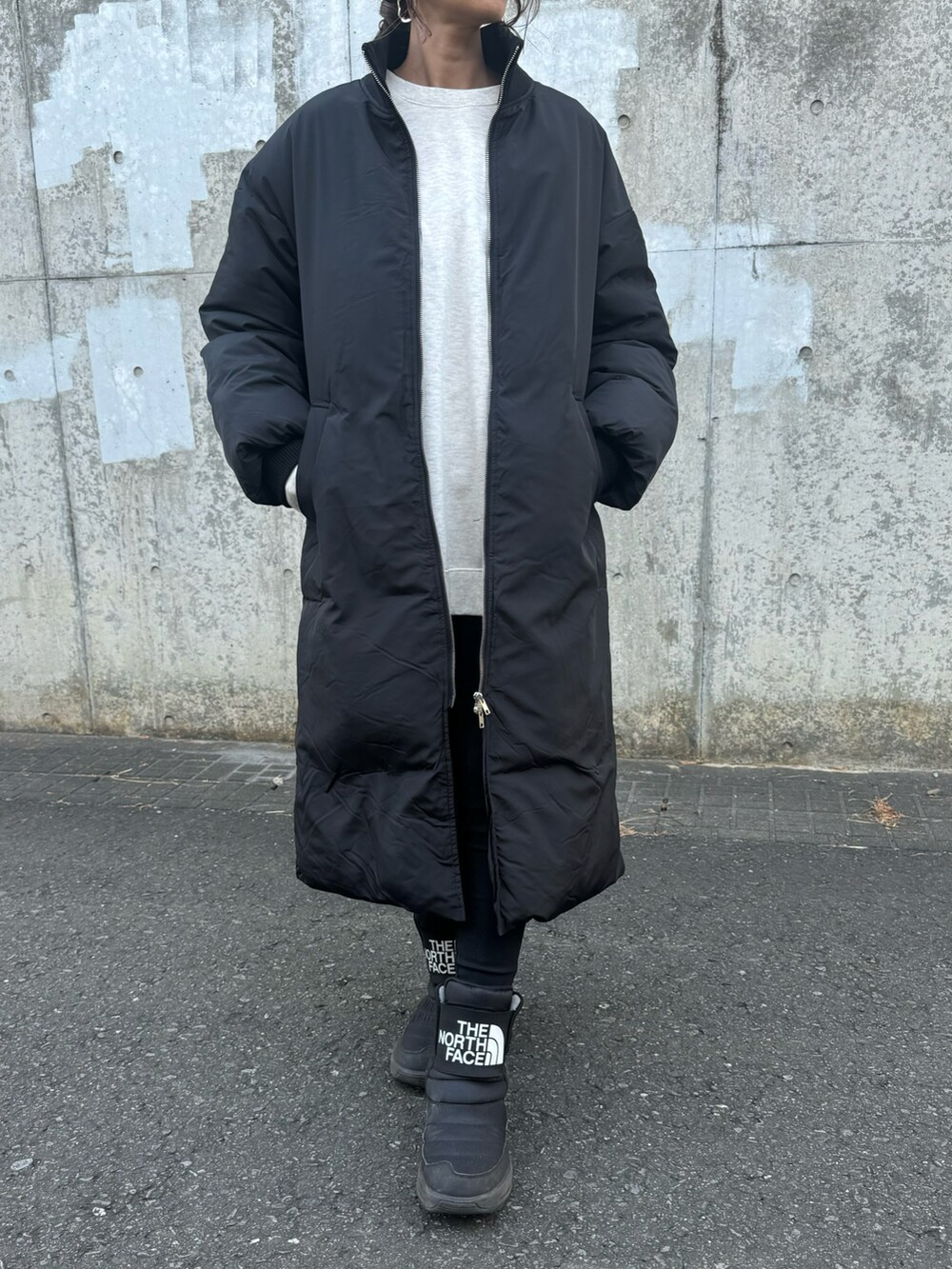 ブラック系のその他アウター、ホワイト系のスウェット、ブラック系のその他パンツを着用したレディースの冬コーディネートの2枚目の写真