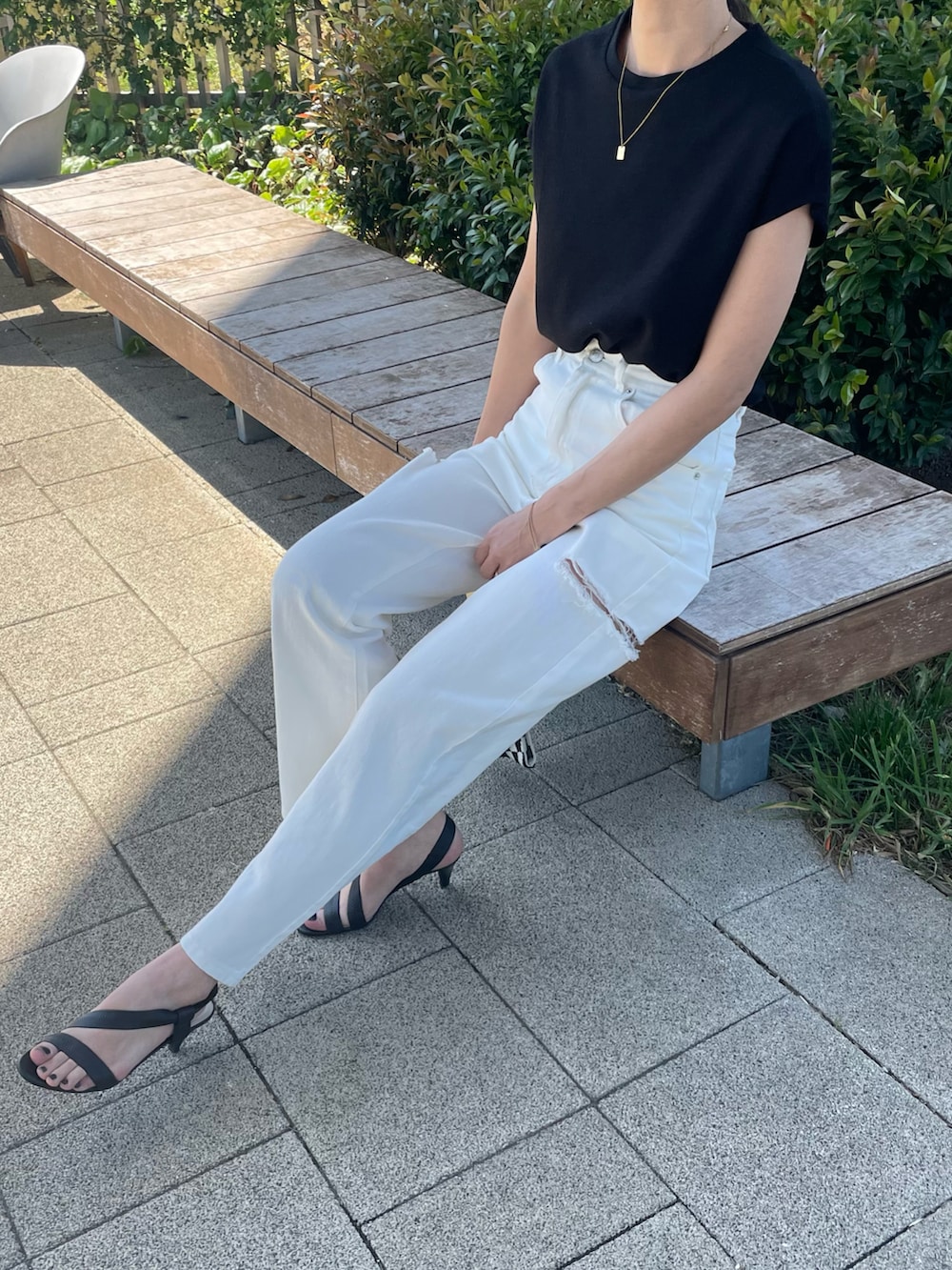 ブラック系のTシャツ/カットソー、ホワイト系のデニムパンツ、イエロー系のハンドバッグを着用したレディースの春コーディネートの3枚目の写真