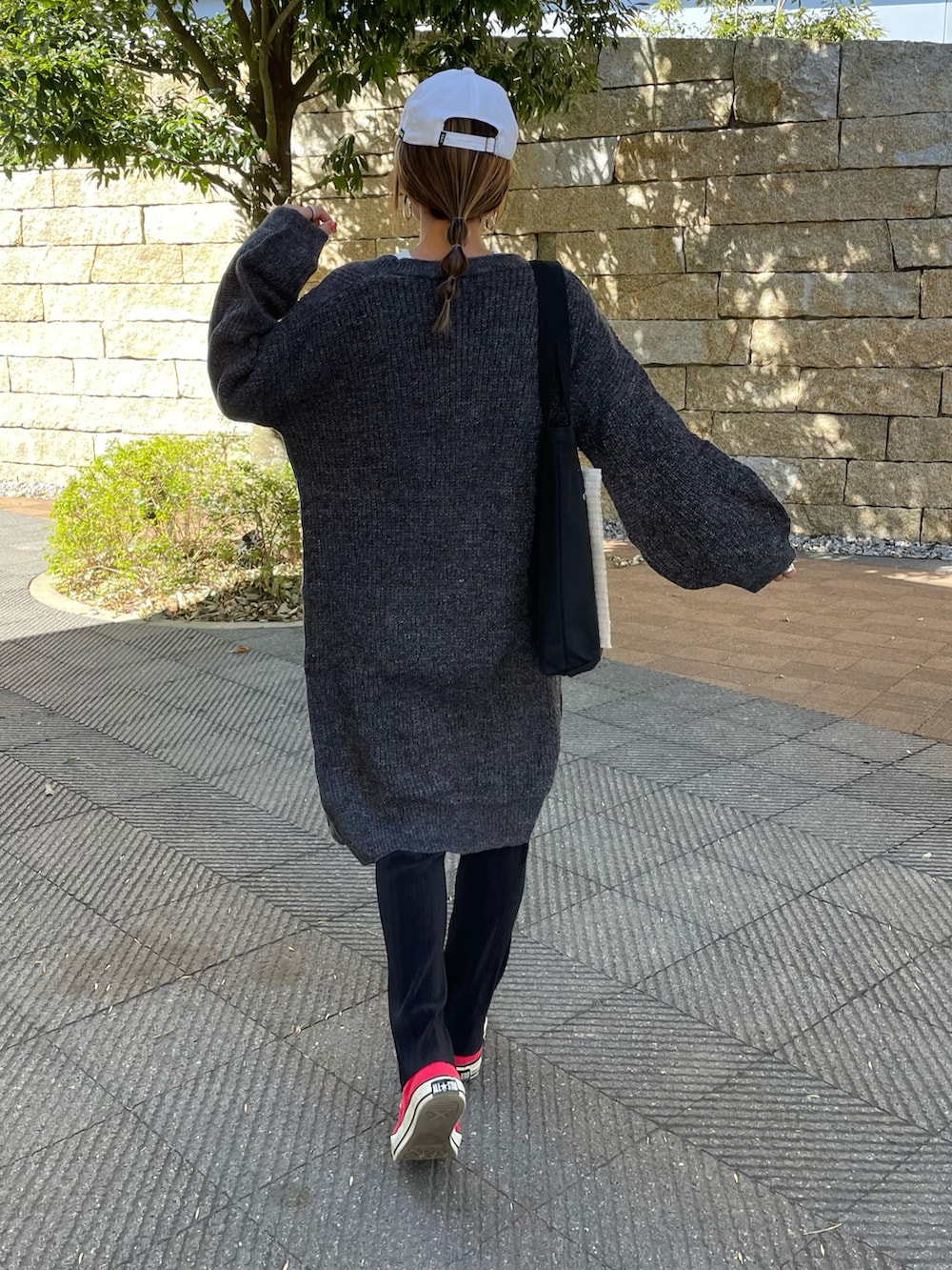 その他のニット/セーター、レッド系のTシャツ/カットソー、ブラック系のトートバッグを着用したレディースの冬コーディネートの4枚目の写真