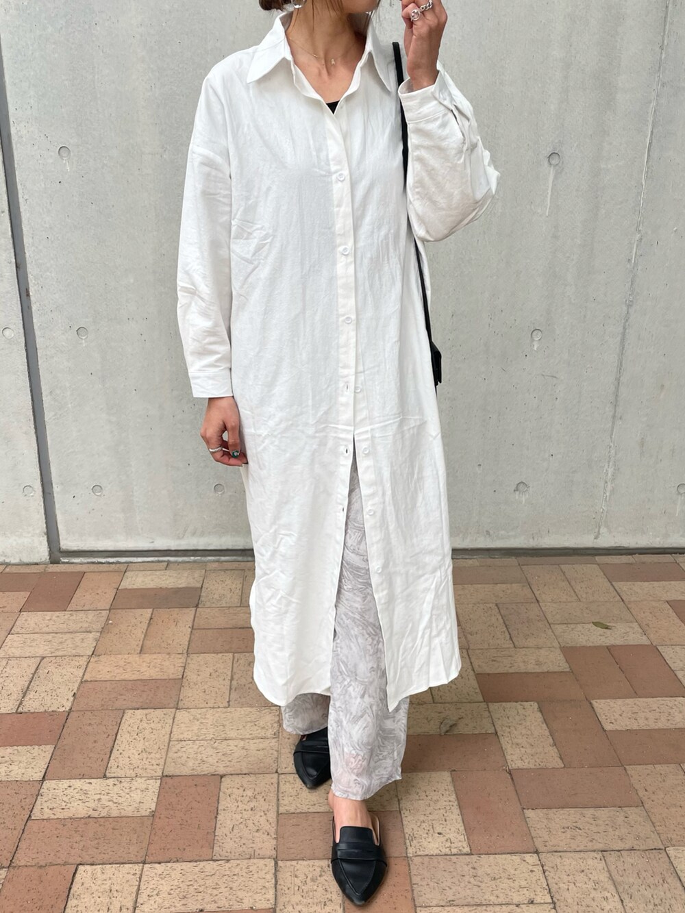 ホワイト系のシャツワンピース、グレー系のその他パンツ、ベージュ系のショルダーバッグを着用したレディースの春コーディネートの4枚目の写真