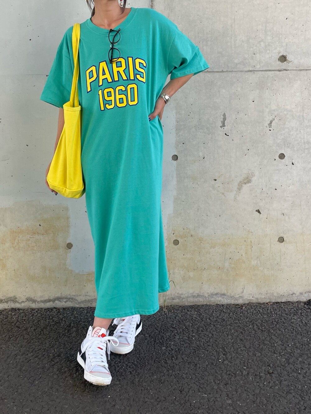 ブルー系のワンピース、イエロー系のトートバッグ、ホワイト系のスニーカーを着用したレディースの春コーディネートの3枚目の写真