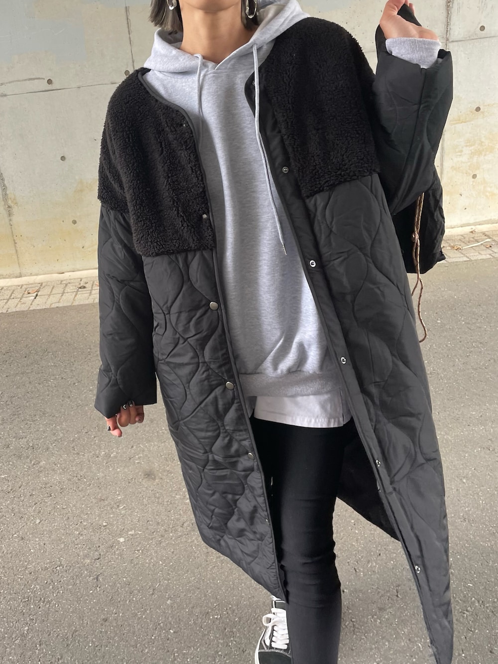 グレー系のパーカー、ブラック系のノーカラージャケット、ブラック系のその他パンツを着用したレディースの秋コーディネートの4枚目の写真