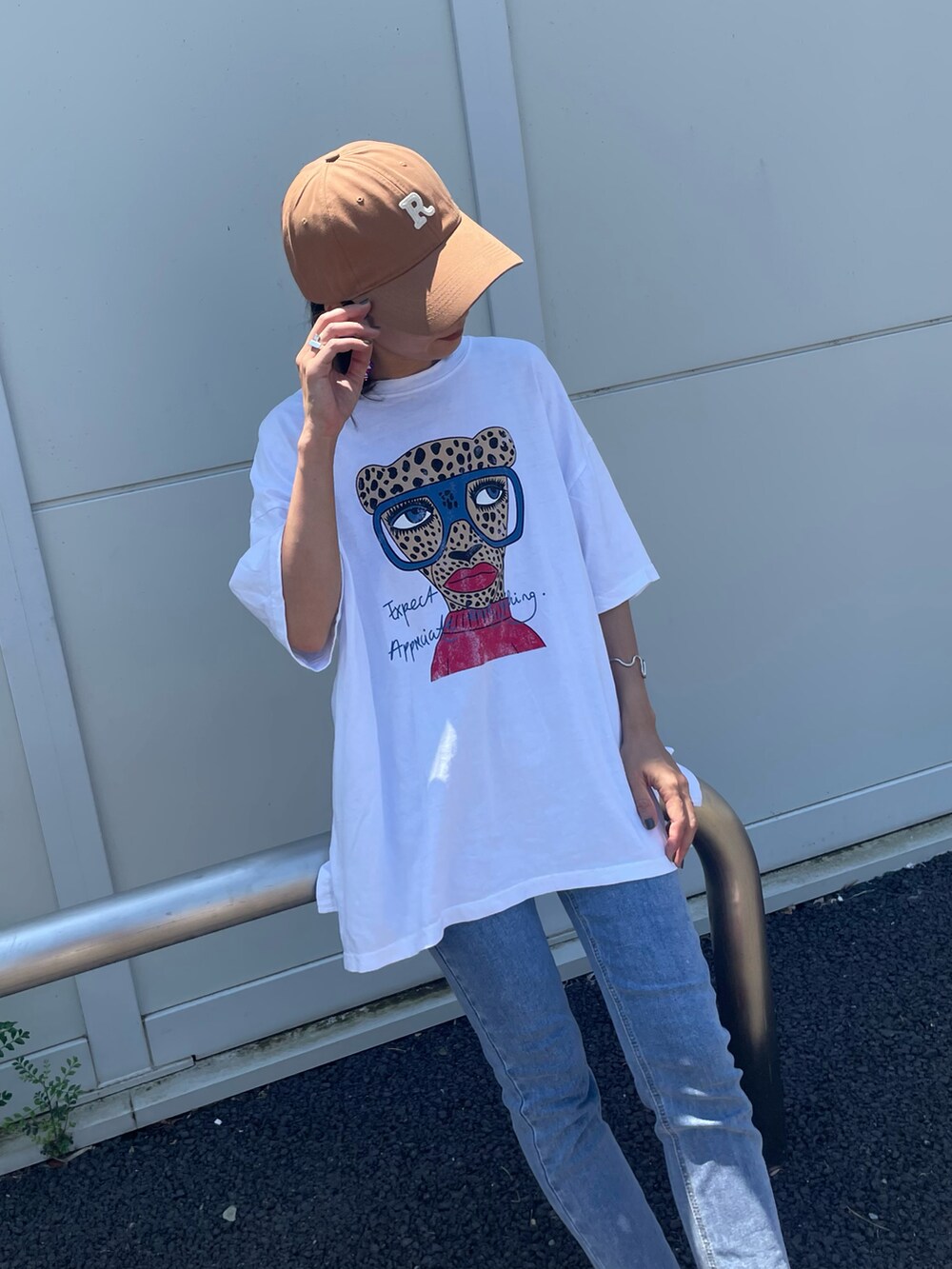 ホワイト系のTシャツ/カットソー、ブルー系のデニムパンツ、レッド系のスニーカーを着用したレディースの夏コーディネートの2枚目の写真