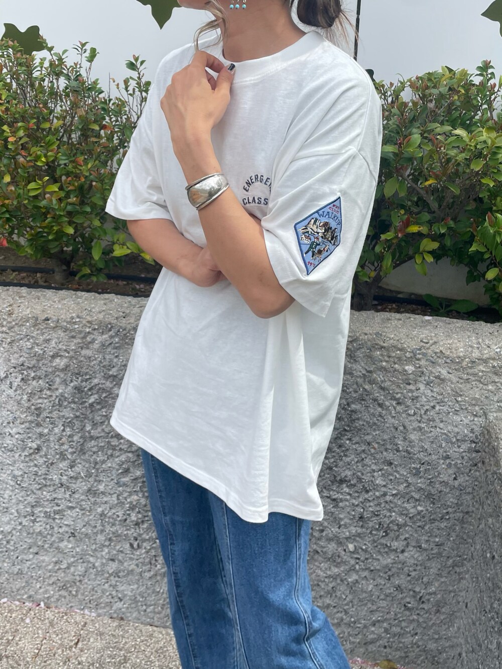 ホワイト系のTシャツ/カットソー、ブルー系のデニムパンツ、ブラック系のサンダルを着用したレディースの春コーディネートの4枚目の写真