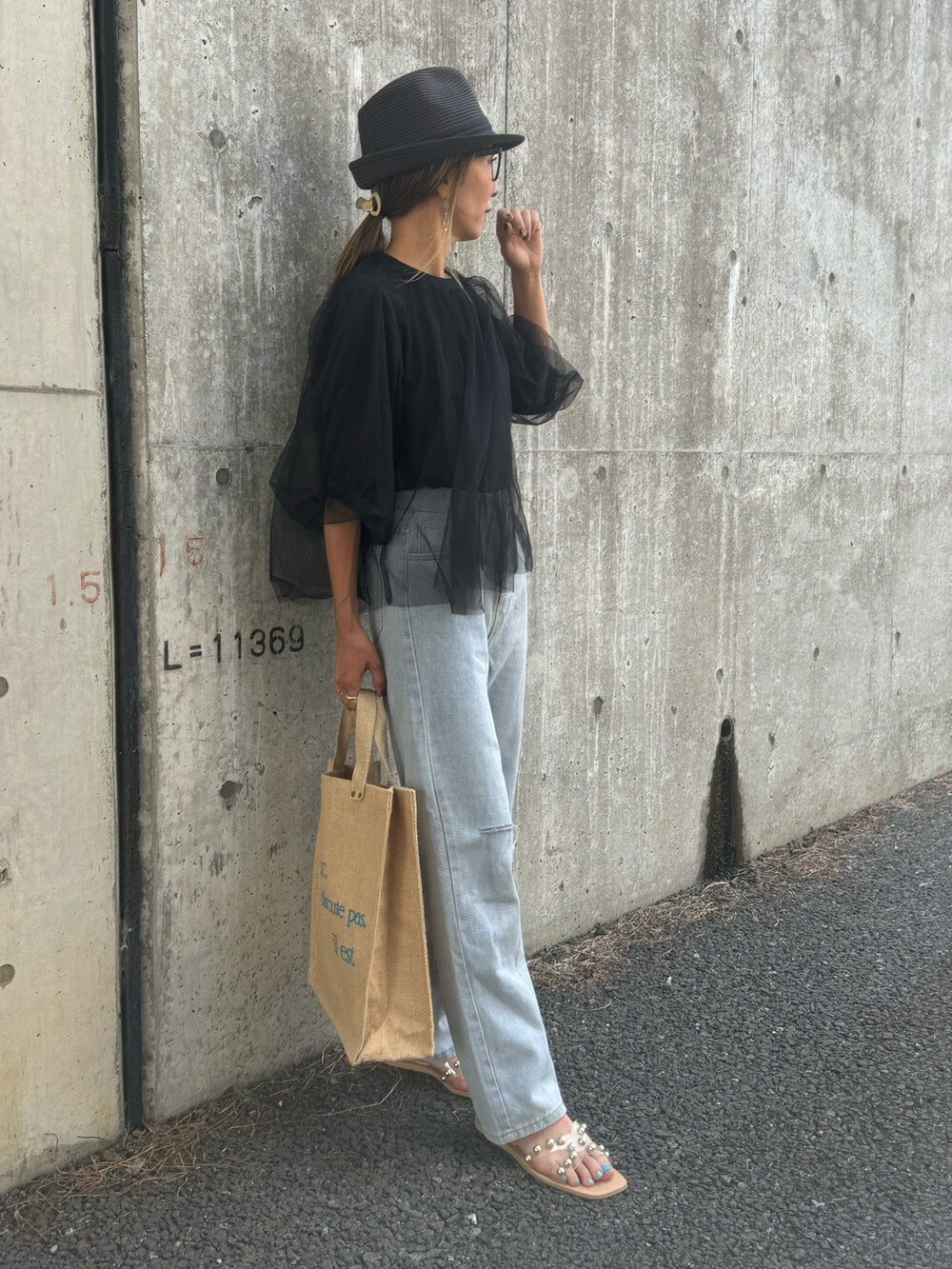 ブラック系のTシャツ/カットソー、ブルー系のデニムパンツ、ピンク系のトートバッグを着用したレディースの夏コーディネートの2枚目の写真