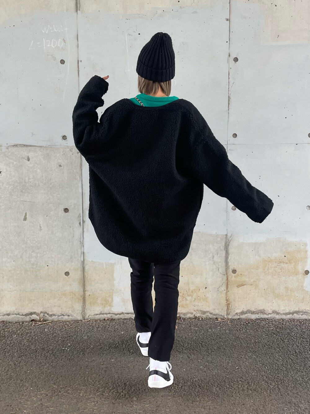 ブラック系のその他アウター、グリーン系のニット/セーター、ブラック系のその他パンツを着用したレディースの冬コーディネートの2枚目の写真