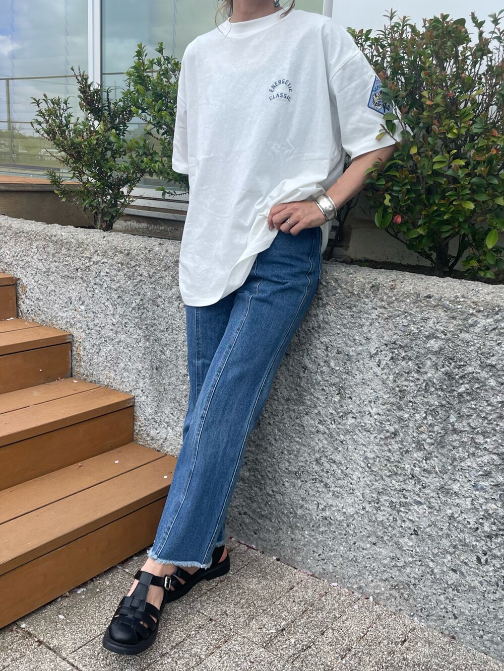 ホワイト系のTシャツ/カットソー、ブルー系のデニムパンツ、ブラック系のサンダルを着用したレディースの春コーディネートの2枚目の写真