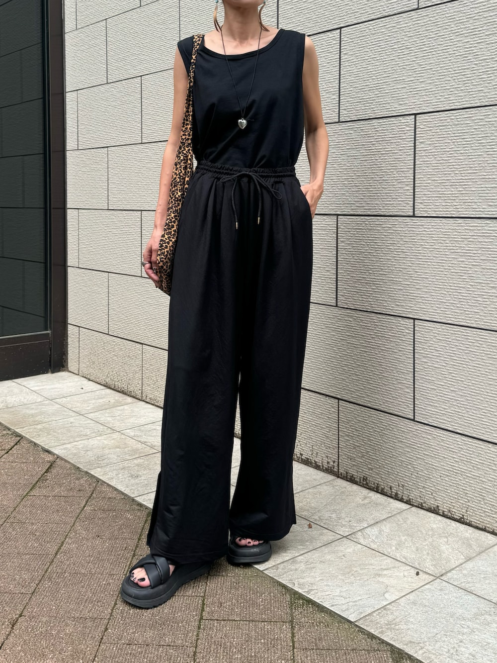 ブラック系のタンクトップ、ブラック系のその他パンツ、ブラウン系のショルダーバッグを着用したレディースの夏コーディネートの2枚目の写真