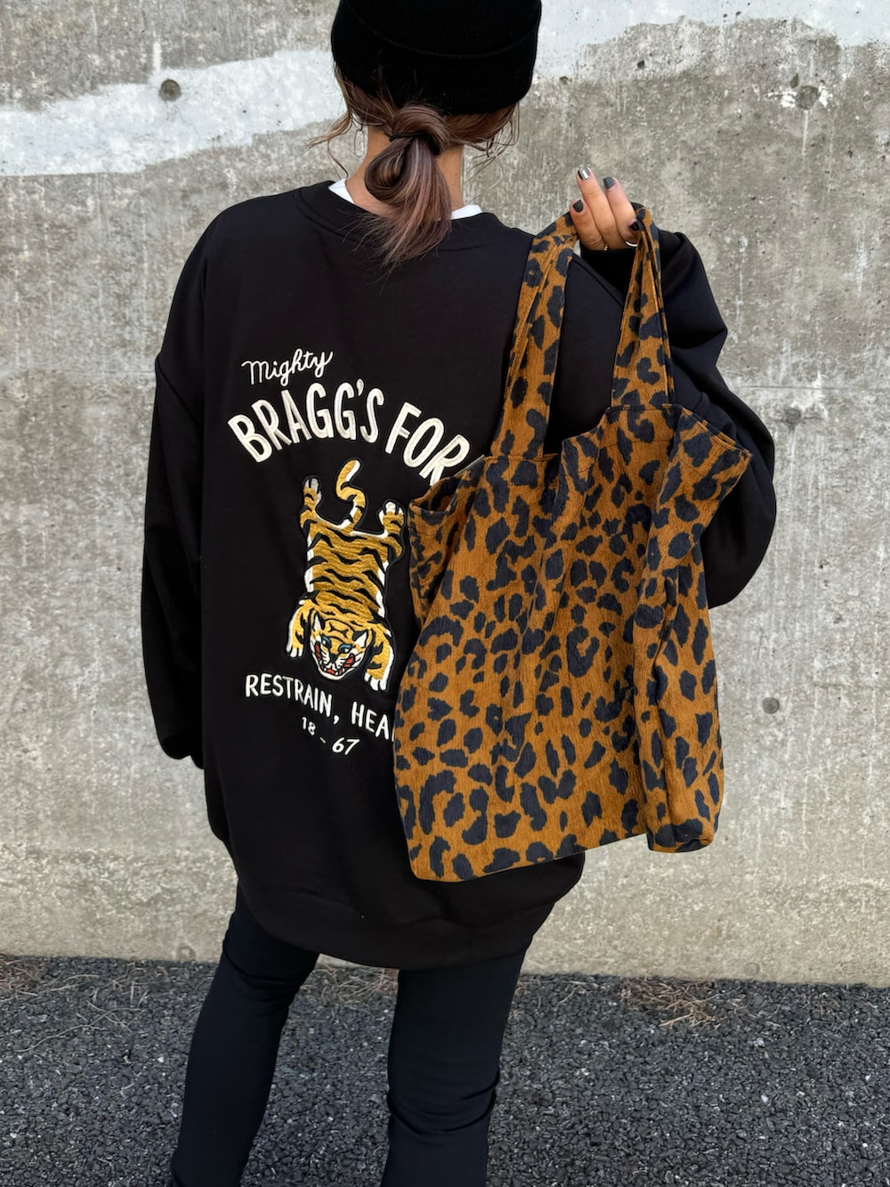 ブラック系のスウェット、ブラウン系のトートバッグ、ブラック系のその他パンツを着用したレディースの秋コーディネートの5枚目の写真