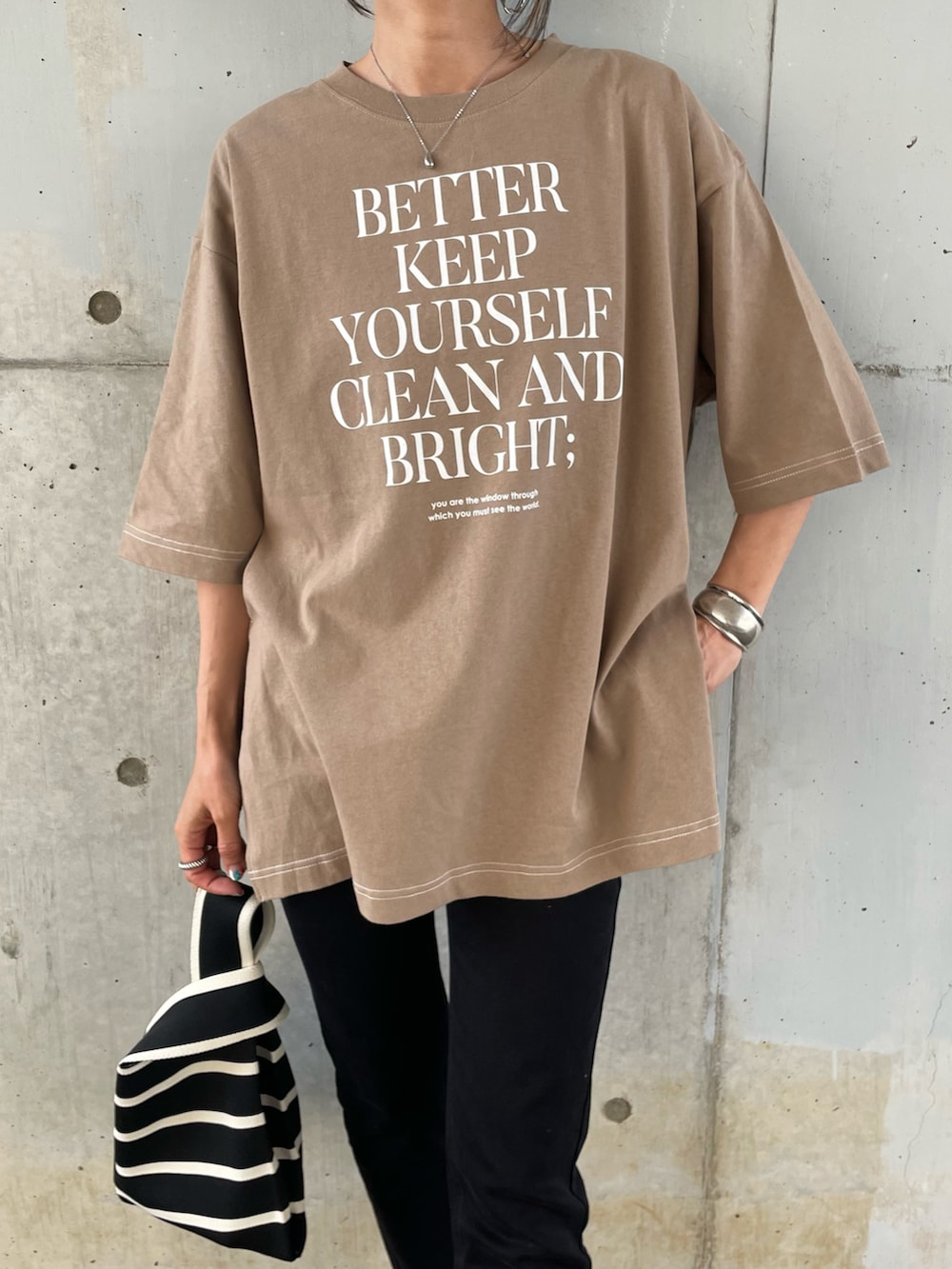 ベージュ系のTシャツ/カットソー、ブラック系のデニムパンツ、ブラック系のハンドバッグを着用したレディースの春コーディネートの4枚目の写真