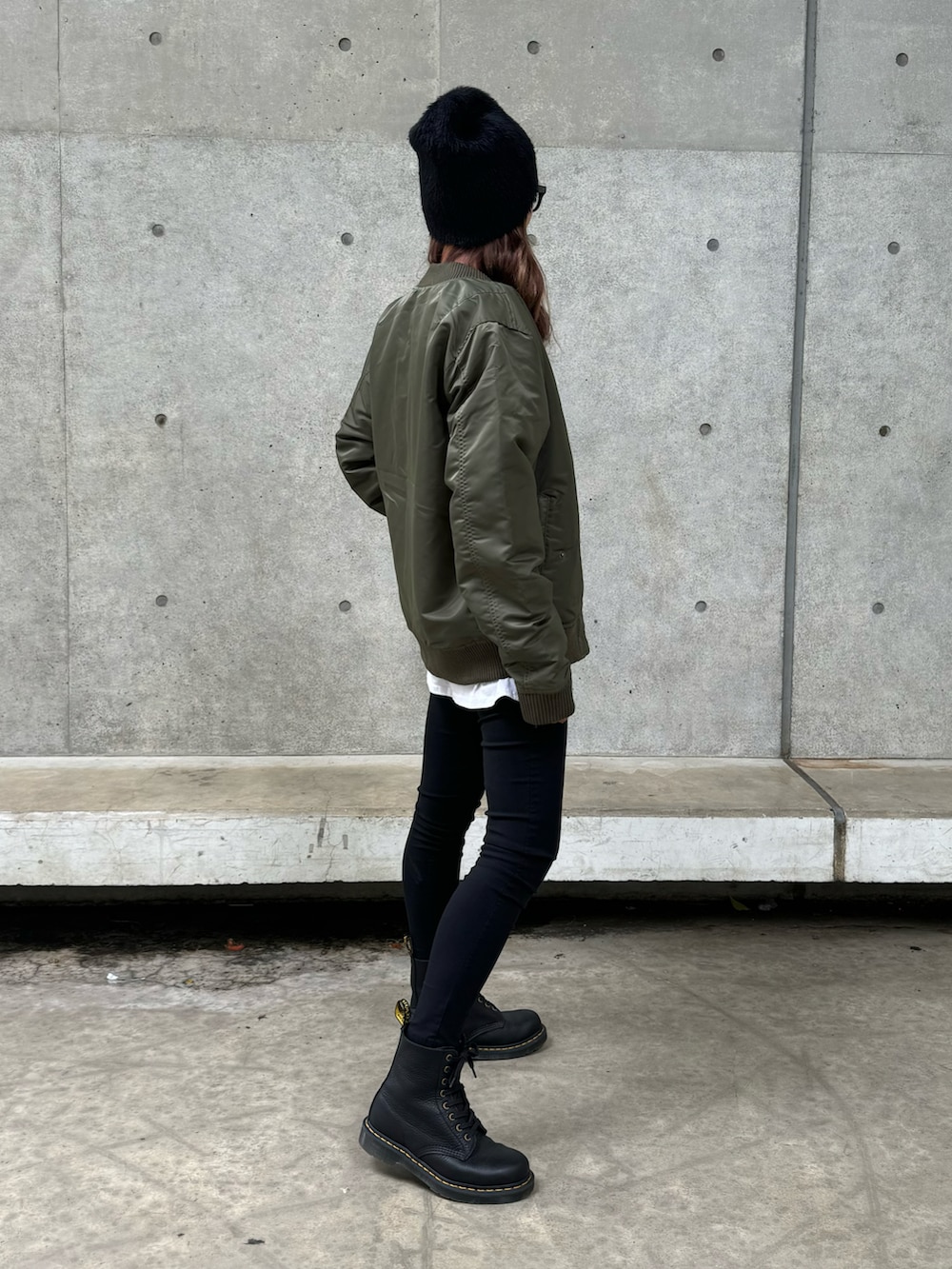 グリーン系のミリタリージャケット、ブラック系のスウェット、ホワイト系のその他パンツを着用したレディースの秋コーディネートの3枚目の写真