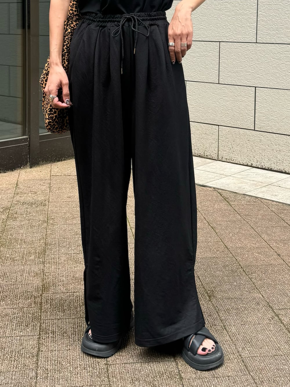 ブラック系のタンクトップ、ブラック系のその他パンツ、ブラウン系のショルダーバッグを着用したレディースの夏コーディネートの4枚目の写真