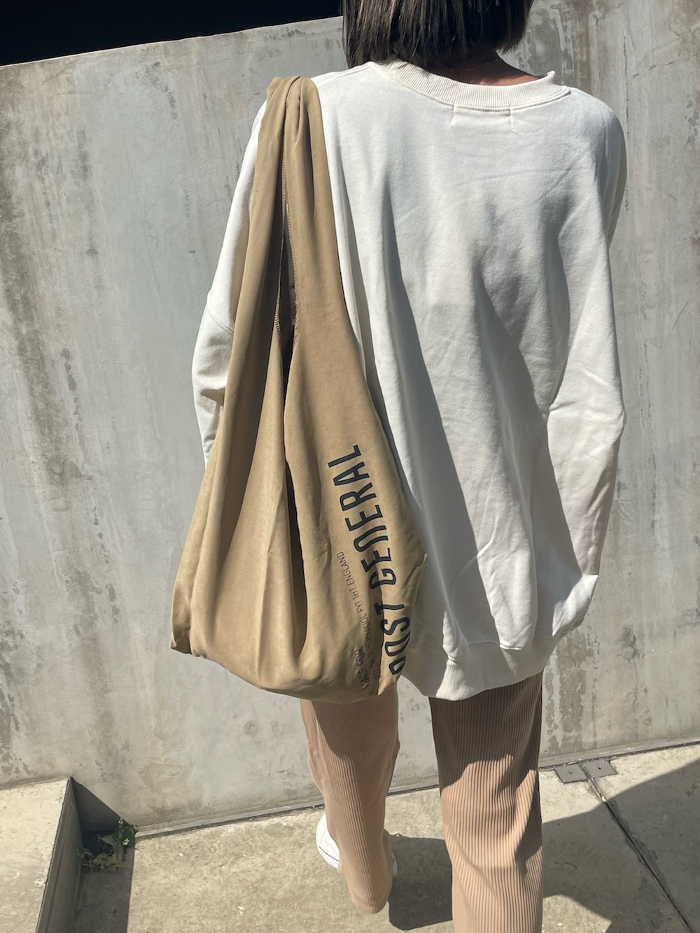 ベージュ系のその他パンツ、その他のエコバッグ/サブバッグ、ホワイト系のスニーカーを着用したレディースの春コーディネートの4枚目の写真