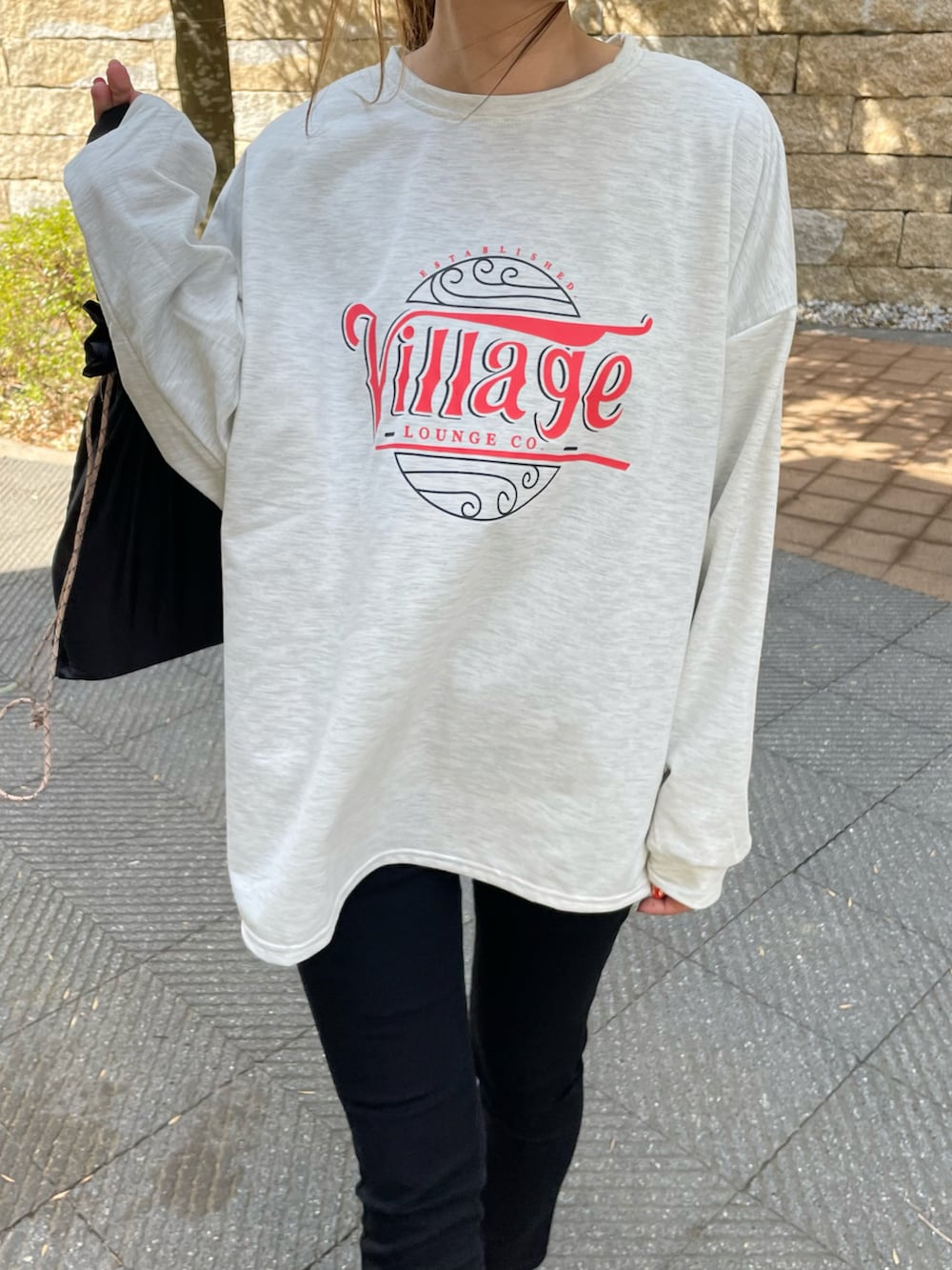 ブラック系のその他パンツ、グリーン系のエコバッグ/サブバッグ、レッド系のスニーカーを着用したレディースの春コーディネートの4枚目の写真